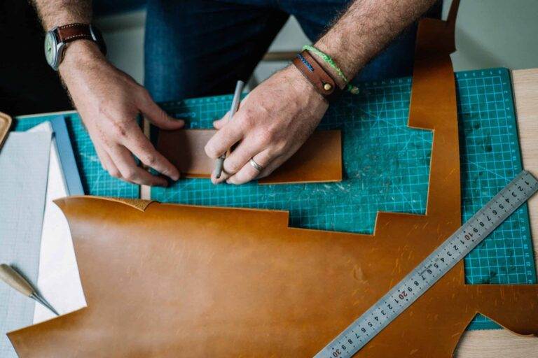 About a man working on a piece of leather.
