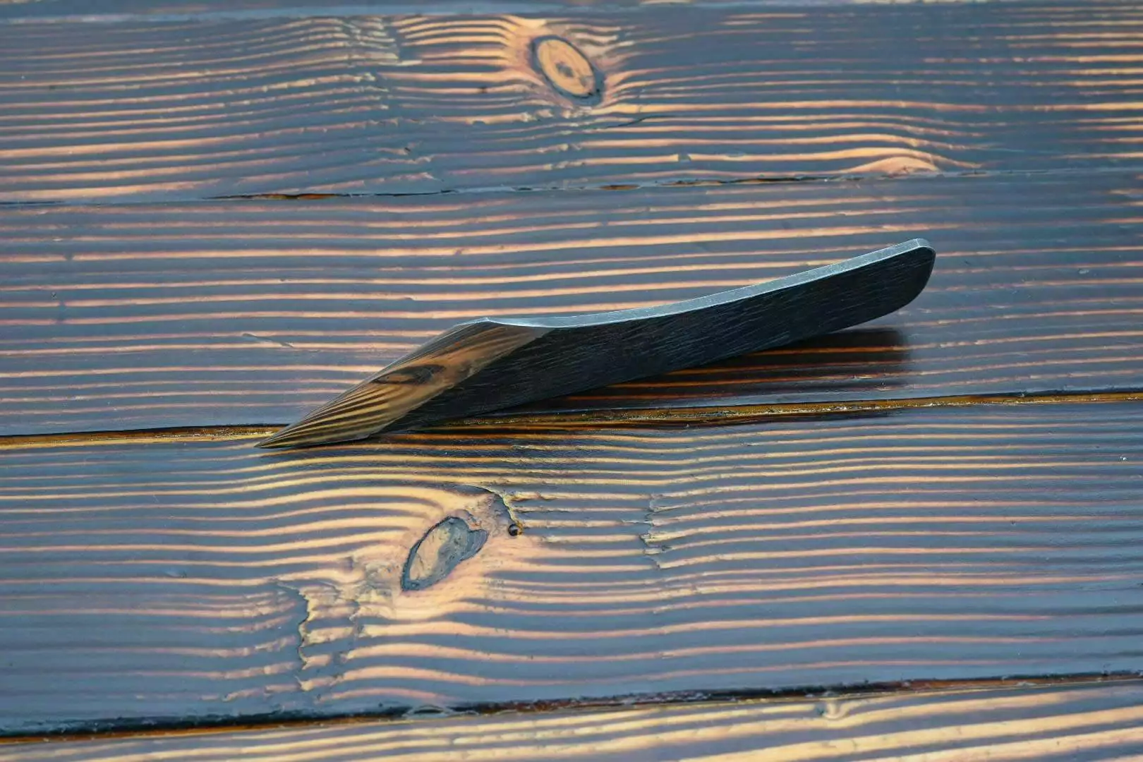 Leather knife, wooden table.