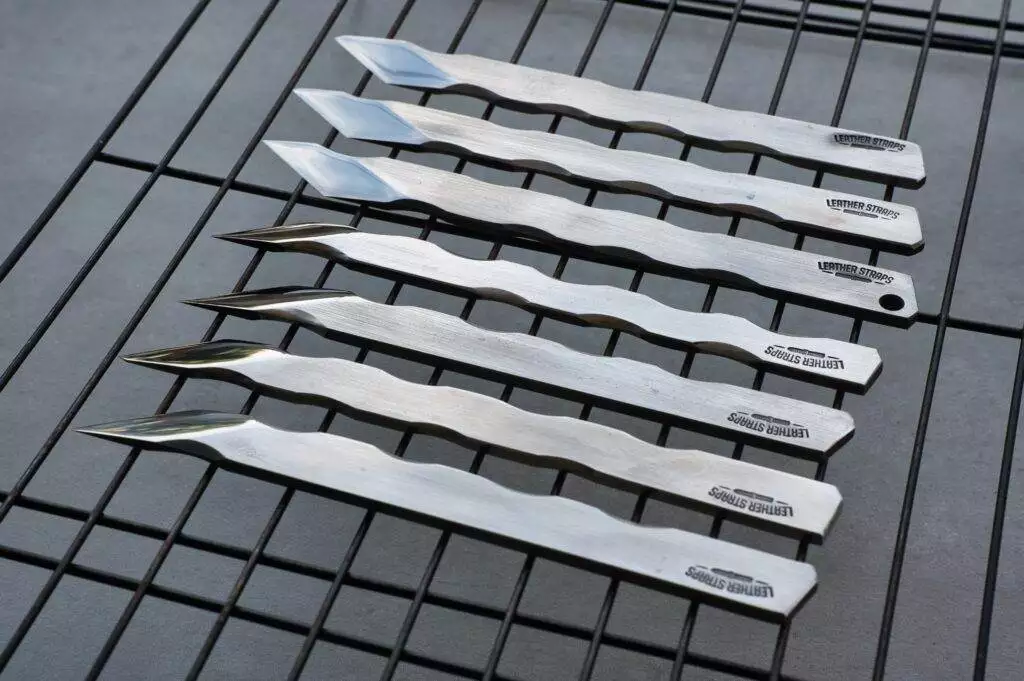 Stainless steel knives on metal rack.