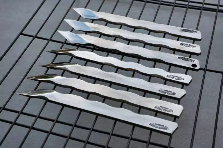 Stainless steel knives on metal rack.