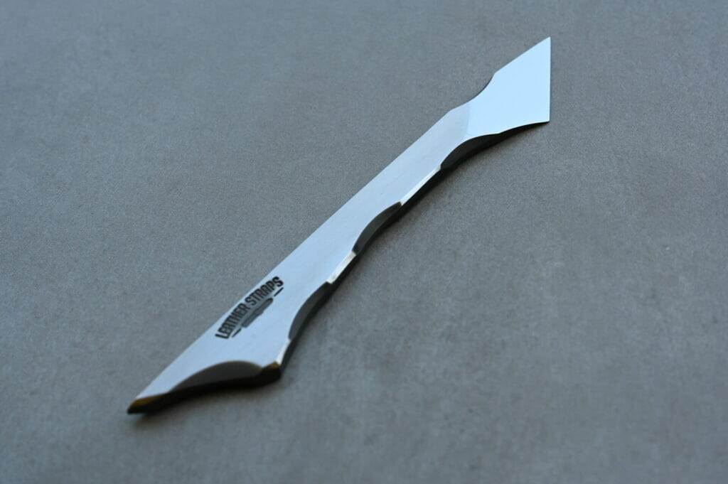 A silver scalpel on a grey surface.