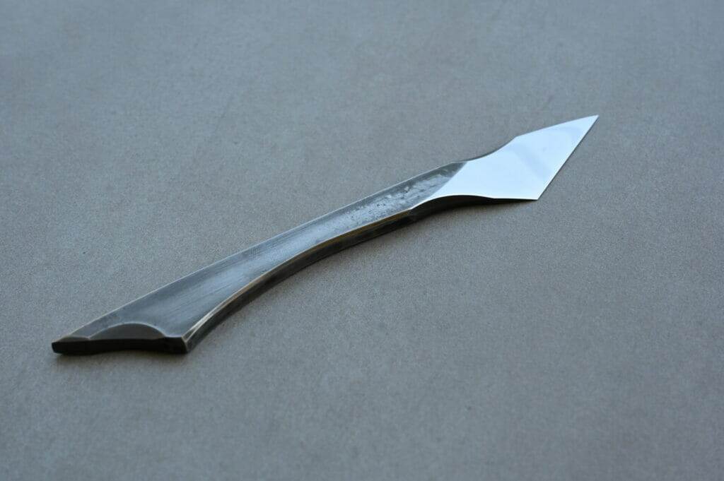 A scalpel with a small blade on a table.