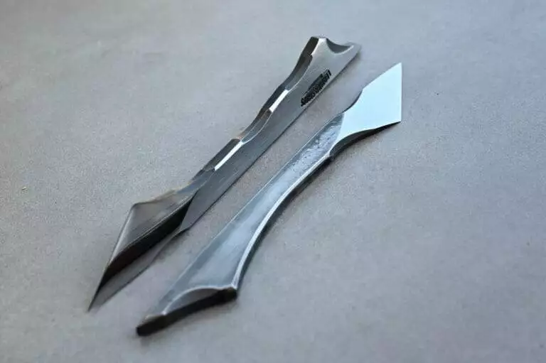 A pair of scalpels on a table next to each other.