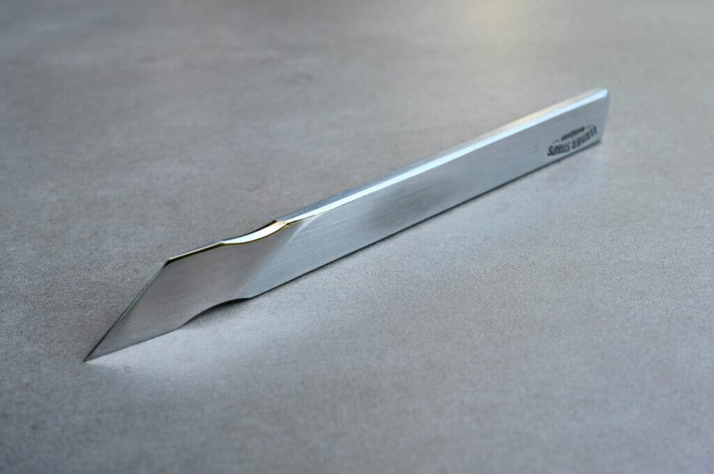 A scalpels is sitting on a surface.