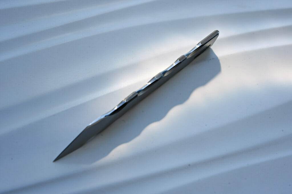 A scalpel resting on a sandy surface.