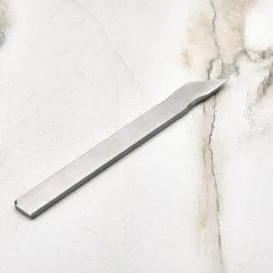The Scribe Scalpel elegantly displayed on a smooth marble surface.