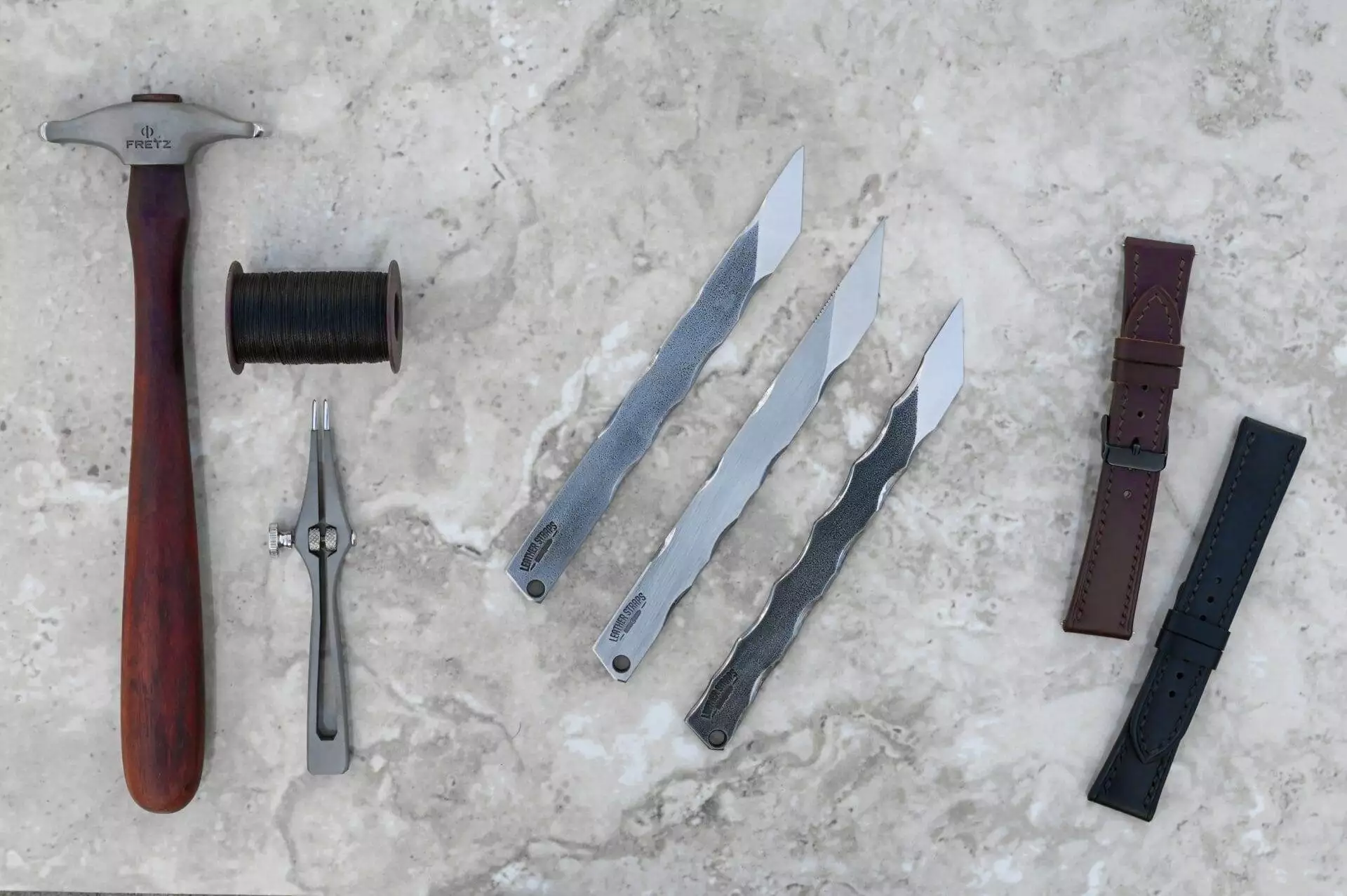 A set of hammer tools and a stone surface.