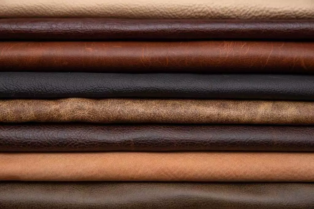 A stack of different types of leather, categorized in a comprehensive guide for leather craft projects.