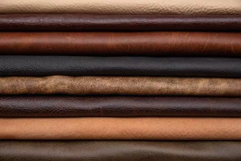 A stack of different types of leather, categorized in a comprehensive guide for leather craft projects.