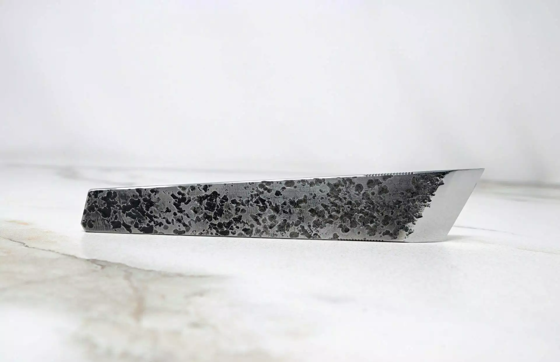 A knife with black and white speckles on it in the FRIDAY THE 13th - Triple Blade Special edition.