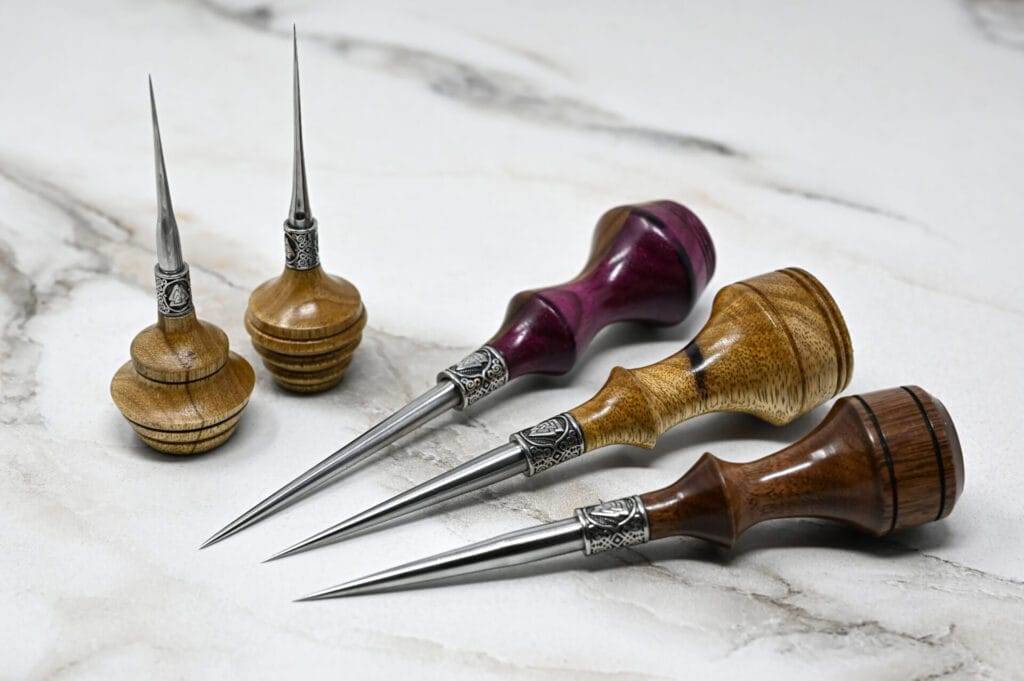 Four wooden 3 Leathercraft Knife Holiday Special on a marble table, perfect for leathercraft projects.