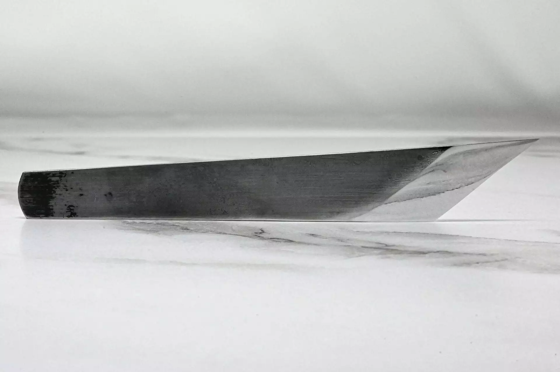 A knife on top of a marble surface.