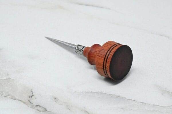 A pre-release sale Japanese Leather Knife + Small Awl delicately placed on a marble surface.