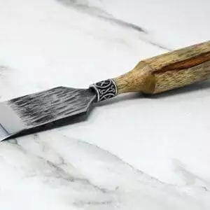 A Japanese Leather Knife with a wooden handle on a marble surface.