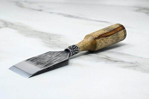 Description: A Japanese Leather Knife on top of a marble countertop with a touch of Japanese aesthetic.