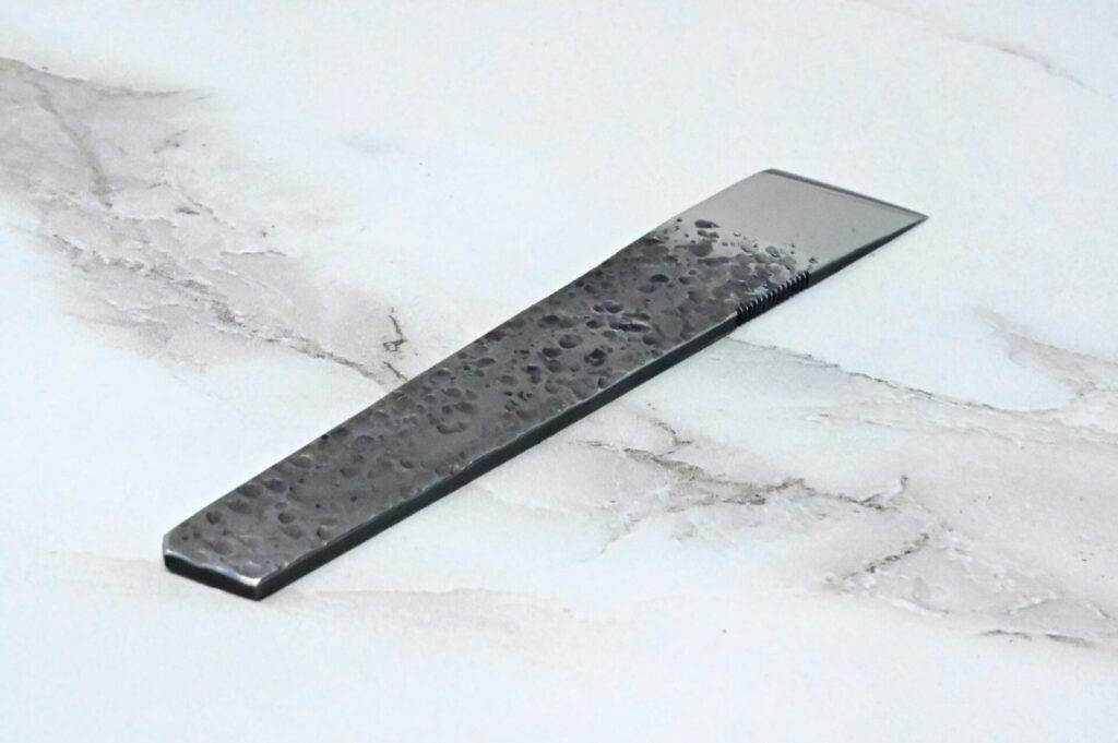 A black and silver hair comb on a marble surface with leather straps.