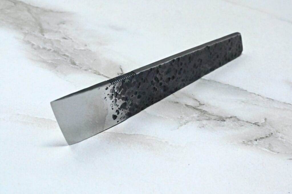 A black hair comb on a marble surface, perfect for a Leathercrafter.