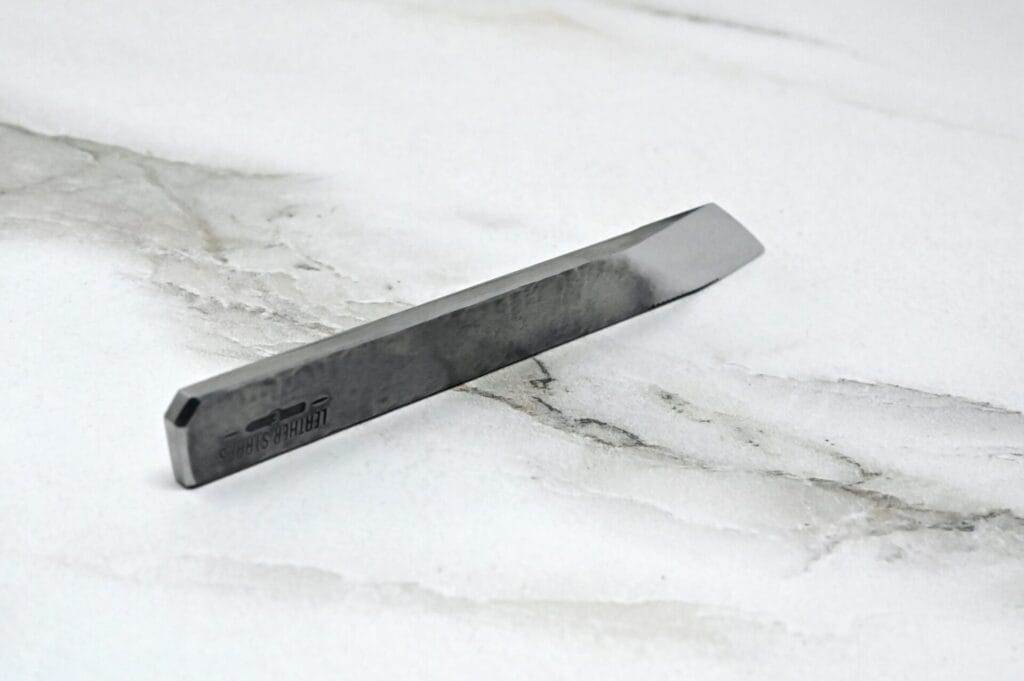 A piece of metal is sitting on top of a marble surface.