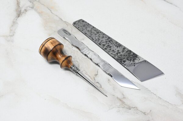 A 4th of July Leathercraft Bundle - 20 Sets Only!, a pair of metal tweezers, and a knife with a textured metal blade on a light marble surface.