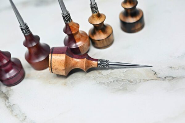 A collection of Premium Handmade to Order Scratch and Poking Awls, arranged on a white marble surface.