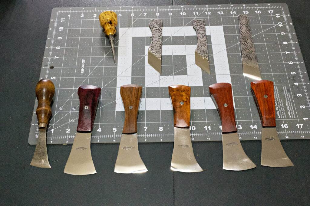 Placed on a cutting mat with a measuring grid, The Halloween 3 Piece Special includes knives and a tool, all featuring stylish wooden handles. Ideal for any kitchen or even a haunting Halloween arrangement!