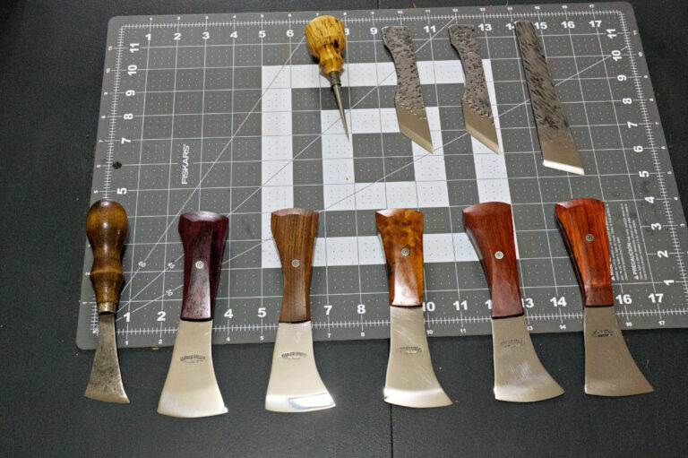 The Halloween 3 Piece Special, featuring woodworking tools with wooden handles, is artfully displayed on a cutting mat and includes various chisels and gouges.