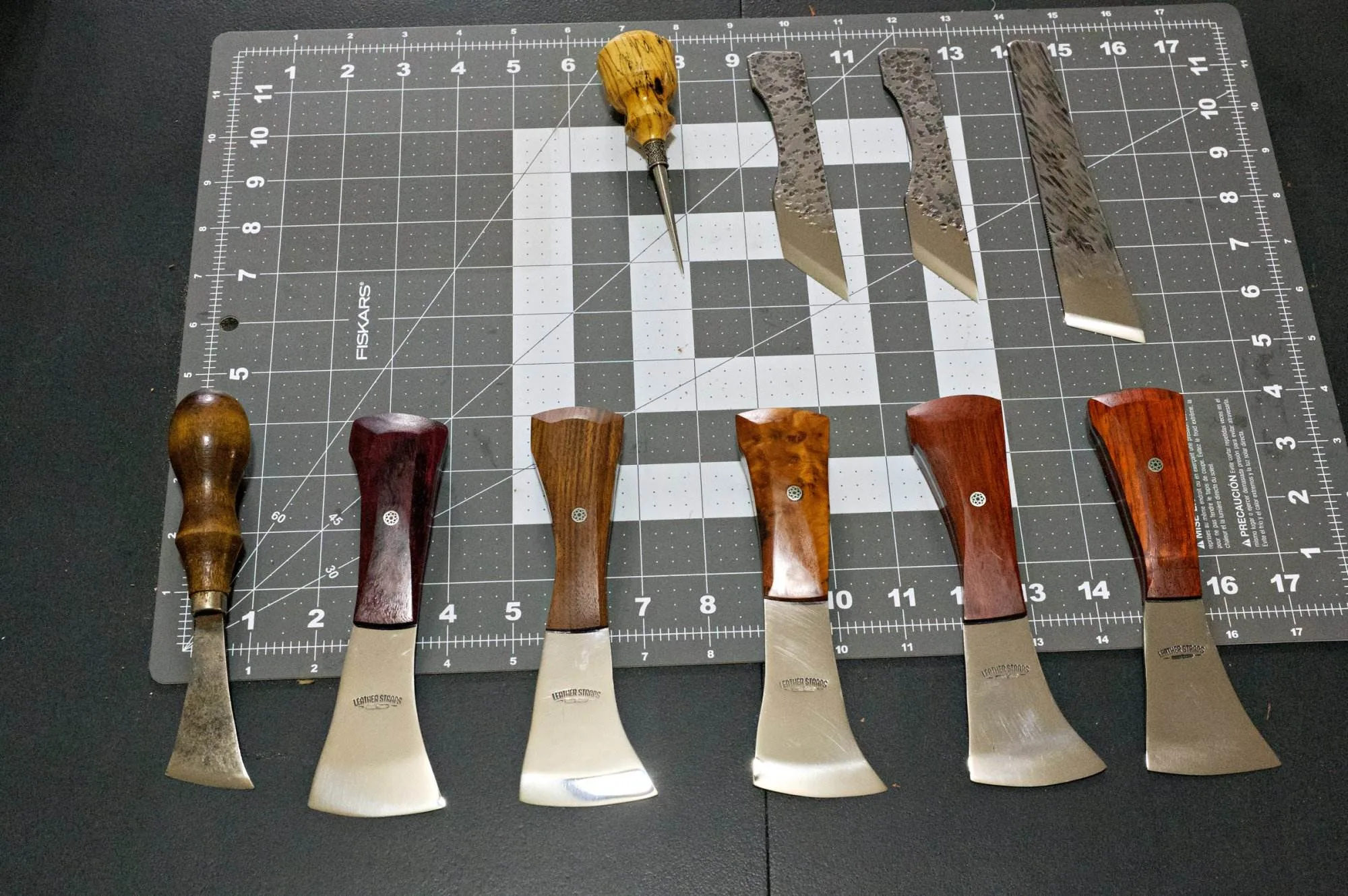 The Halloween 3 Piece Special, featuring woodworking tools with wooden handles, is artfully displayed on a cutting mat and includes various chisels and gouges.