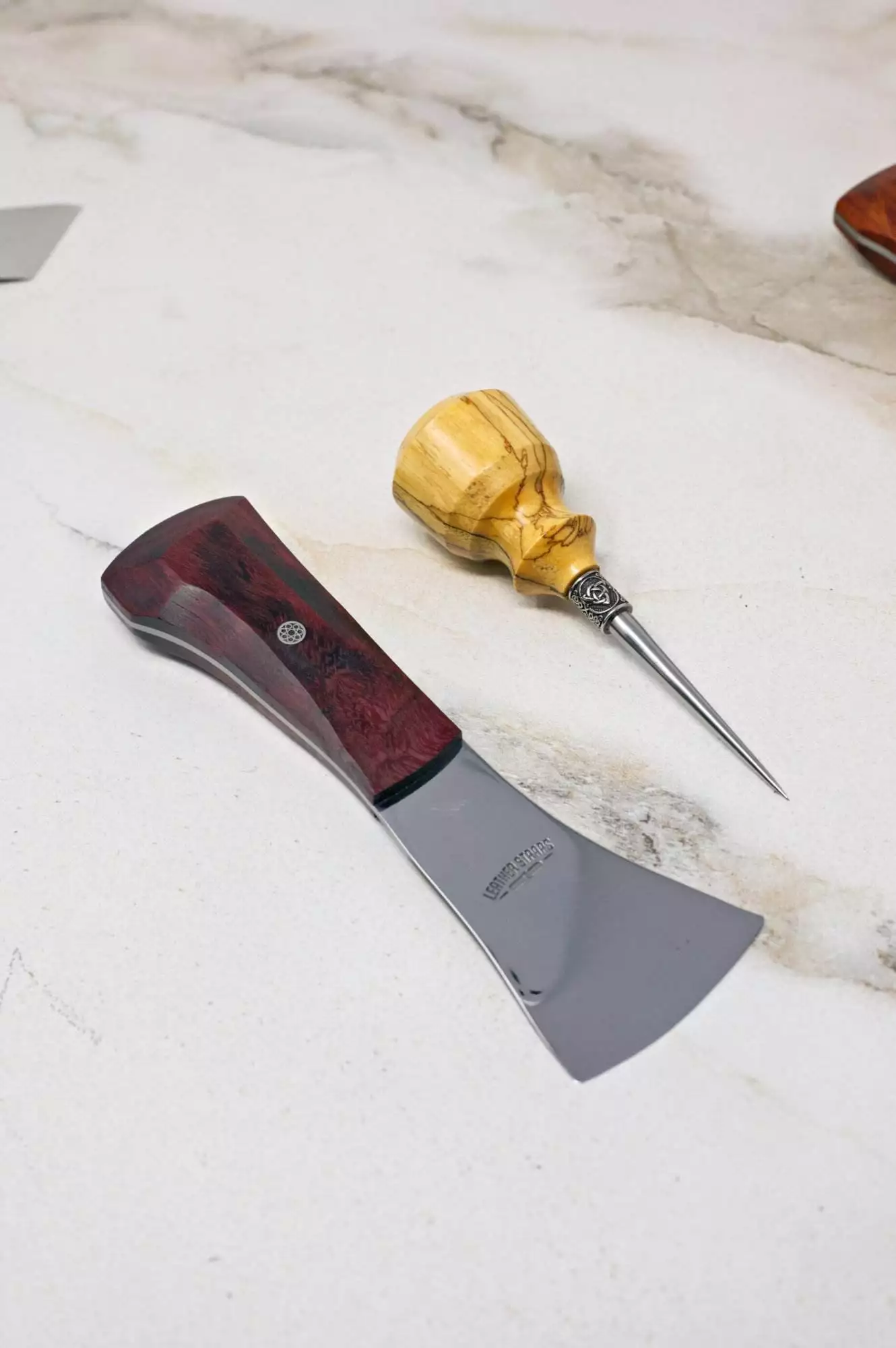 The Halloween 3 Piece Special includes a chisel with a dark wood handle and a pointed awl with a light wood handle, beautifully showcased on a marble surface.