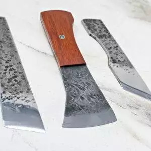 Three "Signature" American Leather Knives featuring textured metal blades and wooden handles are arranged on a marble surface.