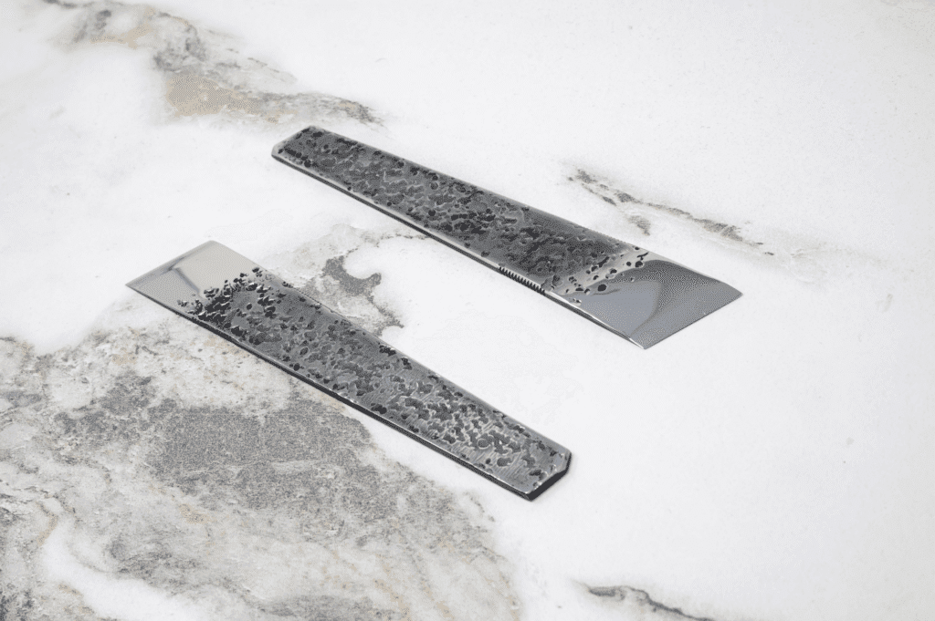 The 2025 Valentine's Day - The Essentials Special features two textured metal bars poised elegantly on a marbled surface, adding sophistication to your setting.