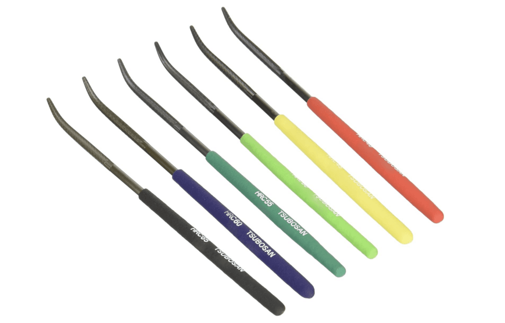 Six colorful dental root elevators with curved metal tips and rubberized handles in black, blue, green, yellow, red, and orange.